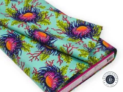 Gefaltetes Stoffstück des Anemonenmusters in Mint auf weißem Hintergrund.