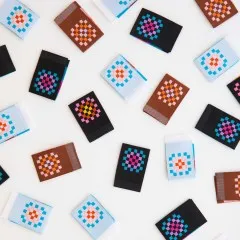 Sarah Hearts Weblabels „Granny Squares" in vier Farbvarianten dicht gestreut in Nahaufnahme