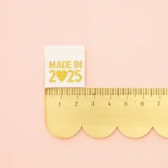 „Made in 2025“-Label neben einem goldenen Lineal zum Größenvergleich.