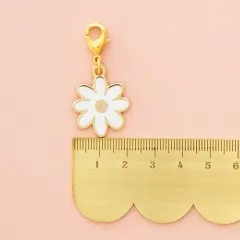 Zipper Charm neben einem goldenen Lineal zum Größenvergleich.