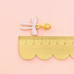 Zipper Charm neben einem goldenen Lineal zum Größenvergleich.