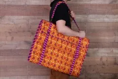 Mann trägt den großen Ruler Wrap in orange-pinkem Muster unter dem Arm.
