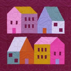 Quiltblock mit vier bunten Häusern in Rosa, Gelb, Mint und Orange auf Beere