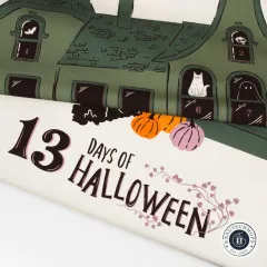 Aufgerollter Baumwollstoff mit Spukhaus-Motiv und Schriftzug 13 Days of Halloween in Schwarz und Rosa