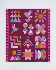Sampler-Quilt Jewel Grotto mit bunten Blöcken auf beerenfarbenem Grund, Hand + Soul 2027 Block of the Month