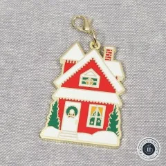 Nahaufnahme des Anhängers in Form eines schneebedeckten roten Hauses mit Türkranz.