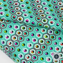 Nahaufnahme des gefalteten Stoffs mit dem Sechseck-Würfel-Muster in Mint, Pink und Gold