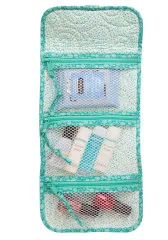 Aufgeklappter Organizer mit drei Netz-Reißverschlusstaschen, gefüllt mit Reiseartikeln und Verbandsmaterial