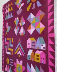 Detailansicht des Jewel Grotto Quilts mit Kolibri, Häusern, Baum und Diamantblöcken auf Beere