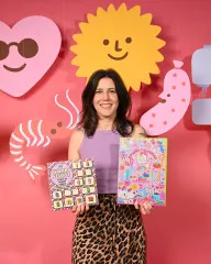 Kylie hält den Sweary Sewist Kalender und den KATM Adventskalender 2026 vor rosa Kulisse