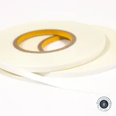 Nahaufnahme der beiden Basting-Tape-Rollen mit sichtbarem gelben Schutzstreifen der Klebeschicht.