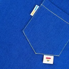 Die Labels „Mama Made" und Herz-Symbol eingenäht an einer blauen Jeans-Gesäßtasche.