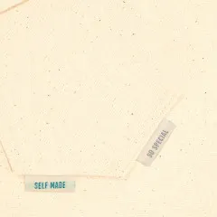 Zwei Labels mit den Sprüchen Self Made und So Special eingenäht in einen cremefarbenen Stoffsaum.
