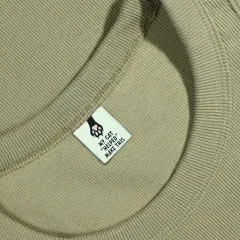 Pfotenabdruck-Label eingenäht in den Rückenausschnitt eines salbeigrünen Sweatshirts.