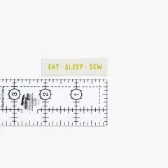 Label 'Eat Sleep Sew' mit gelbem Schriftzug und Lineal zum Größenvergleich.