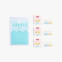Nahaufnahme der drei Label-Motive: „My Mama Made It", „Mama Made" und Herz-Symbol in Rosa, Gelb und Blau.