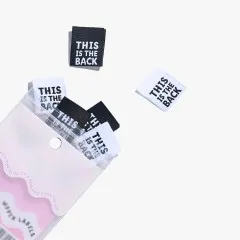 Weißes und schwarzes Label 'This is The Back' schwebend neben der leicht geöffneten Verpackung