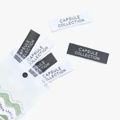 Labels 'Capsule Collection' beim Herausfallen aus der Verpackung.