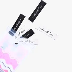 Labels 'Made with Love' beim Herausfallen aus der Verpackung.