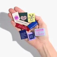 Alle neun Labels des Sets in einer aufgehaltenen Hand präsentiert.