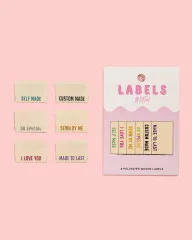 Alle sechs Labels neben der Original-Verpackung auf rosa Hintergrund.