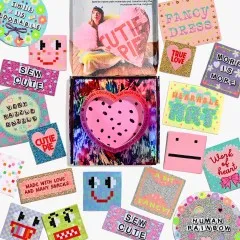 Alle Labels des Sets um die geöffnete Box mit Cutie-Pie-Herz und Rachel-Burke-Foto herum ausgebreitet.