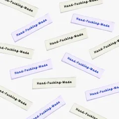 Mehrere Labels 'Hand-Fucking-Made' verstreut in der Draufsicht.