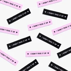 Mehrere Labels 'I Didn't Fuck It Up' verstreut in der Draufsicht.
