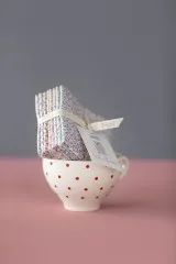 Sophie-Basics-Stoffstapel dekorativ in einer gepunkteten Tasse arrangiert