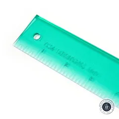 Nahaufnahme der grünen Lineal-Kante mit Markenaufdruck 'CM Designs, Inc.' und Zoll-Skala.