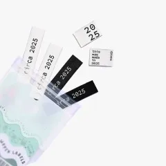 Die Labels des „Circa 2025"-Sets lose verstreut, teils aus der geöffneten Verpackung ragend.