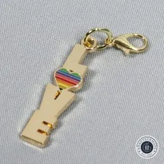 Nahaufnahme des Anhängers mit dem Schriftzug 'Love' und einem kleinen Regenbogen-Herz.