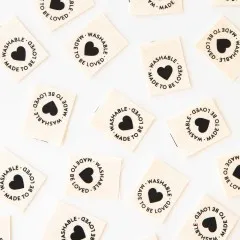 Waschbare Sarah Hearts Weblabels „Made to be Loved" locker verteilt auf weißem Untergrund