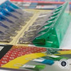Nahaufnahme der blauen und grünen Magic Clips in der Verpackung mit Blick auf die Metallclips im Detail
