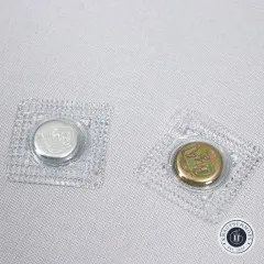 Nahaufnahme eines silbernen und eines goldfarbenen Magnetverschluss-Teils nebeneinander