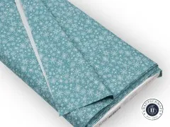 Gefalteter türkiser Baumwollstoff mit weißen Schneeflocken auf Moda Stoffballen