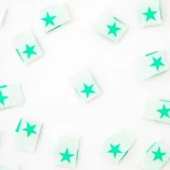 Alle acht mintgrünen „Star"-Weblabel verstreut, teils quer liegend.