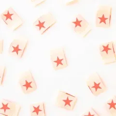 Alle acht neonpinken „Star"-Weblabel verstreut, teils quer liegend.