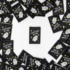 Mehrere schwarze Weblabels mit goldglitzerndem Geist-Motiv im Kreis um ein einzelnes zentrales Label angeordnet.