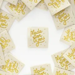 Mehrere Sarah Hearts Weblabels „Made for you" mit goldenem Glitzer-Schriftzug kreisförmig um ein einzelnes Label angeordnet.