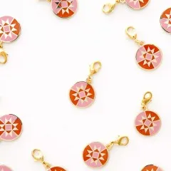 Mehrere Quilt-Star-Zipper-Charms locker verstreut auf weißem Untergrund.
