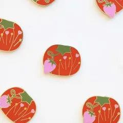 Mehrere Tomato-Pin-Cushion-Needle-Minder locker verstreut auf weißem Untergrund.