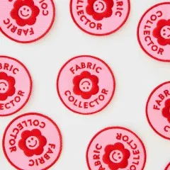 Nahaufnahme mehrerer „Fabric Collector"-Patches mit lächelndem Blumengesicht, dicht verstreut.