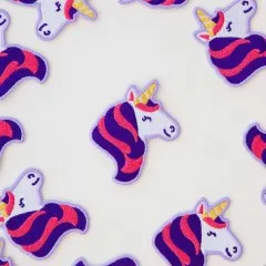 Nahaufnahme mehrerer Einhorn-Patches mit lila-pinker Mähne, dicht verstreut.