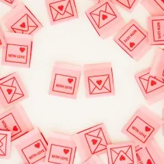 Mehrere rosa Weblabels mit Umschlag- und "With Love"-Motiv im Kreis um zwei zentrale Labels angeordnet.