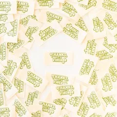 Mehrere cremefarbene Weblabels mit grünem Retro-Schriftzug "Thanks, It's Vintage" im Kreis um ein einzelnes zentrales Label angeordnet.