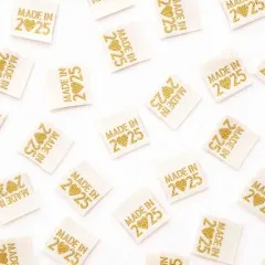 Weitere Ansicht verstreuter „Made in 2025“-Labels, teils quer liegend.