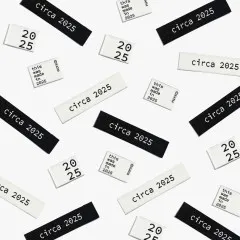 Zahlreiche „circa 2025"-, „2025"- und „this was made in 2025"-Labels in Schwarz und Creme als Flatlay-Musteraufnahme locker verstreut.