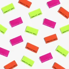 Zahlreiche „Quality Shit"-Labels in Neongelb, Neonorange und Knallpink als Flatlay-Musteraufnahme locker verstreut.