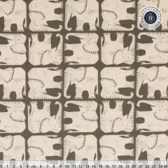 Nahaufnahme des grafischen Elefanten-Rastermusters in Creme auf dunklem Graugrün, mit Zentimeter-Lineal.